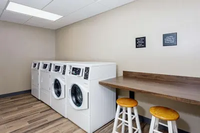 a laundry room with a washer and dryer and two stools at Hampton Inn By Hilton Ocoee Orlando in Orlando