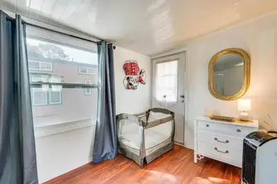 a bedroom with a bed and a mirror and a window at The Hidden Gem Cottage in Kissimmee
