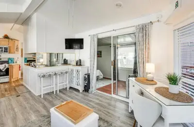 a kitchen with white cabinets and a table in a room at The Hidden Gem Cottage in Kissimmee