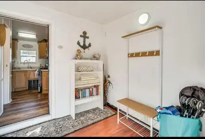 a living room with a table and a kitchen at The Hidden Gem Cottage in Kissimmee