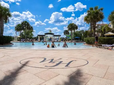 a pool at a resort with people in it at Luxury Disney Villa 5BR With Private Pool and Spa (4 Miles from Disney) in Orlando