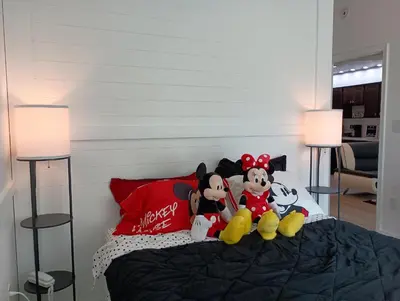 a group of stuffed animals sitting on top of a bed at 3 beds DisneyFree Shuttle in Orlando