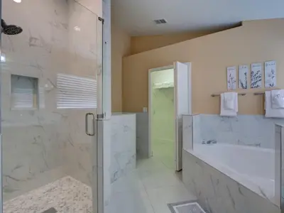 a bathroom with a shower and a tub and a shower stall at Pool home 5 miles to Disney Great for families in Orlando