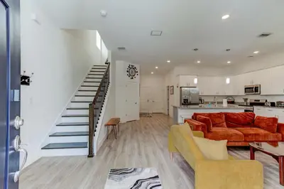 a living room with a couch and a kitchen at The Hub Downtown in Sanford