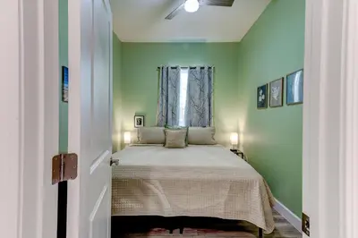 a bedroom with a bed with green walls and a window at The Hub Downtown in Sanford