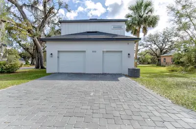 a white garage with two doors on a driveway at The Hub Downtown in Sanford