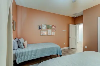 two beds in a room with orange walls at The Hub Downtown in Sanford