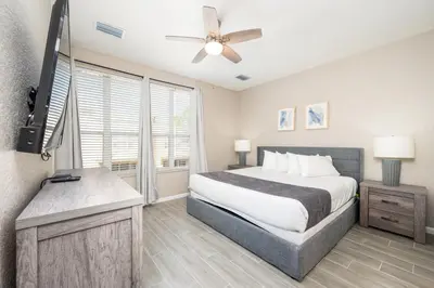 a bedroom with a bed and a flat screen tv at Beautiful Family Townhome, Near The Parks - 8000-104 in Orlando