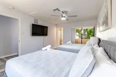 a bedroom with two beds and a flat screen tv at Charming Lakeview Retreat I in Orlando
