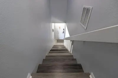 a stairway with white walls and a white door at Charming Lakeview Retreat I in Orlando