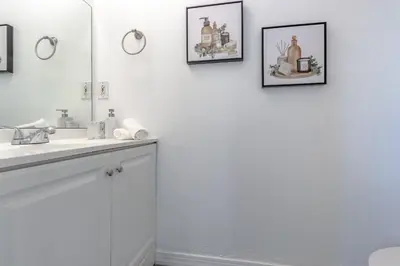 a white bathroom with a sink and a mirror at Charming Lakeview Retreat I in Orlando