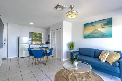 a living room with a blue couch and a table at Charming Lakeview Retreat I in Orlando