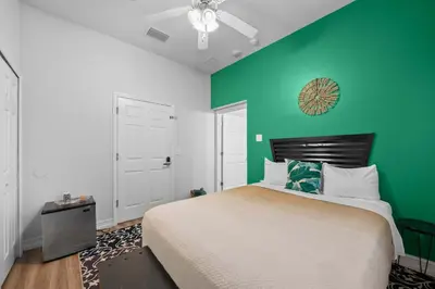 a bedroom with a bed and a green wall at Banana Leaf Villa-Island Groove-Standard Suite in Orlando