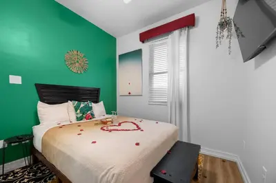 a bedroom with green walls and a bed with a bedspread at Banana Leaf Villa-Island Groove-Standard Suite in Orlando