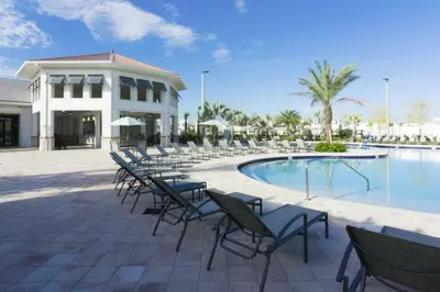 a group of chairs sitting next to a swimming pool at Perfect Disney Getaway House 6BR5BA • Private Pool at Storey Lake Resort SL4788 in Kissimmee