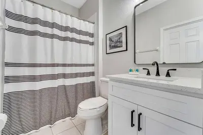 a bathroom with a toilet and a shower curtain at Windsor Hills Townhouse in Orlando
