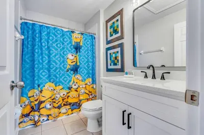 a bathroom with a toilet and a shower curtain at Windsor Hills Townhouse in Orlando