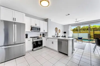 a kitchen with white appliances and a large window at Windsor Hills Townhouse in Orlando