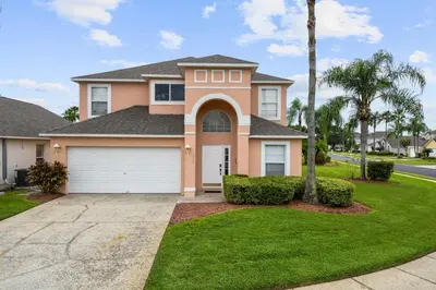 a house with a palm tree and a driveway at Attention Star Wars fans Amazing 6 BR pool in Kissimmee