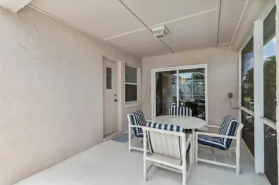 a porch with a table and chairs and a window at Indian Ridge- 4 bedroom home with Game Room in Orlando