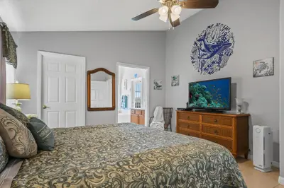 a bedroom with a bed and a television on a dresser at Wheelchair accessible Lakeview 4BR house with pool spa themed rooms game room in Kissimmee