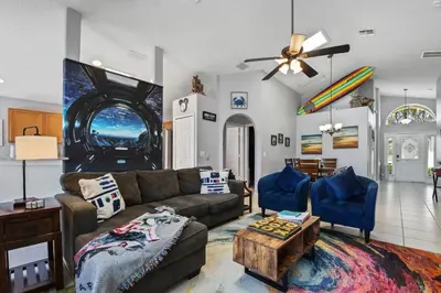 a living room with a couch and a table at Wheelchair accessible Lakeview 4BR house with pool spa themed rooms game room in Kissimmee
