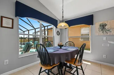 a dining room with a table and chairs and a window at Wheelchair accessible Lakeview 4BR house with pool spa themed rooms game room in Kissimmee