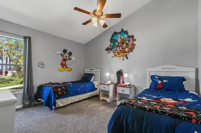 a bedroom with two beds and a ceiling fan at Wheelchair accessible Lakeview 4BR house with pool spa themed rooms game room in Kissimmee