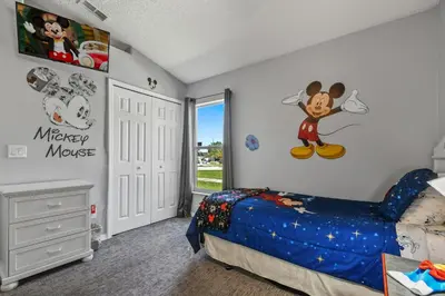 a bedroom with a mickey mouse mural on the wall at Wheelchair accessible Lakeview 4BR house with pool spa themed rooms game room in Kissimmee