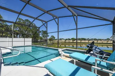 a swimming pool with a view of the water at Wheelchair accessible Lakeview 4BR house with pool spa themed rooms game room in Kissimmee