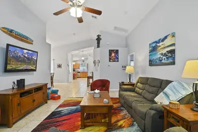 a living room with a couch and a table at Themed 4BR house pool game room 10 min Disney in Orlando