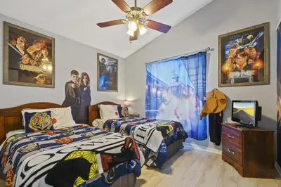 a bedroom with two beds and a ceiling fan at Themed 4BR house pool game room 10 min Disney in Orlando