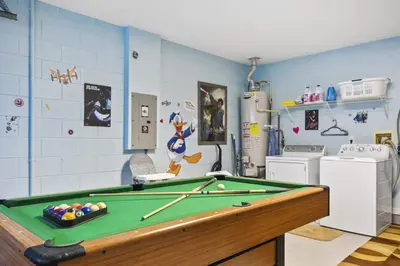 a room with a pool table in a kitchen at Themed 4BR house pool game room 10 min Disney in Orlando