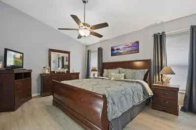 a bedroom with a bed and a ceiling fan at Themed 4BR house pool game room 10 min Disney in Orlando