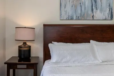 a bed with a wooden headboard and a lamp on a table at Star Wars Themed Home at Windsor Palms in Kissimmee