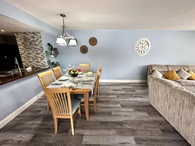 a dining room with a table and chairs and a couch at Disney's Townhome in Kissimmee