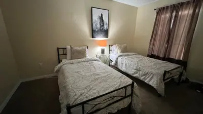 a bedroom with two beds and a picture on the wall at Excelente Casa Vacacional in Kissimmee