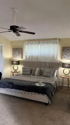a bedroom with a large bed with a ceiling fan at Excelente Casa Vacacional in Kissimmee