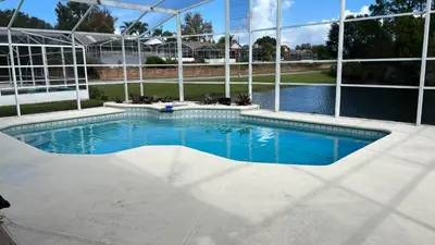 a swimming pool in a building with a large window at Excelente Casa Vacacional in Kissimmee