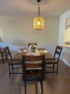 a dining room table with chairs and aendant light at Disney enchantment getaway in Kissimmee