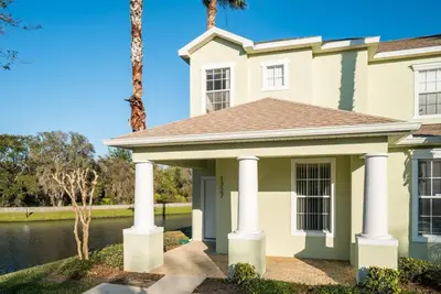 a house with palm trees and a lake at Disney Retreat Lakeview townhome - close to golf in Orlando