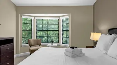 a bedroom with a large white bed and windows at Sunny Stay in FL - 4-Bedroom Townhome by Disney! in Orlando