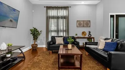 a living room with two black couches and a coffee table at Sunny Stay in FL - 4-Bedroom Townhome by Disney! in Orlando