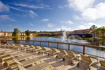 a row of lounge chairs on a deck with a fountain at RO2707BD - 4Bedrms - Regal Oaks in Orlando