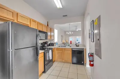 a kitchen with wooden cabinets and a stainless steel refrigerator at RO2707BD - 4Bedrms - Regal Oaks in Orlando