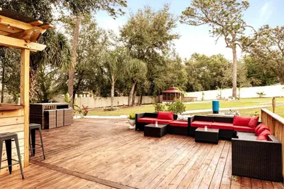 a patio with couches and tables on a wooden deck at Banana Leaf Villa-Marley Junior Suite in Orlando