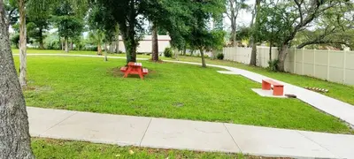 a park with a red picnic table and trees at Banana Leaf Villa-Marley Junior Suite in Orlando