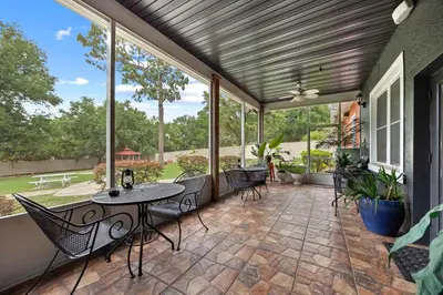 a patio with a table and chairs and windows at Banana Leaf Villa-Vintage Vibes Suites in Orlando