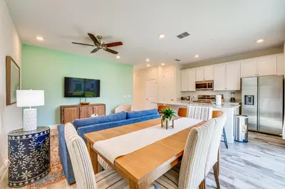 a living room with a blue couch and a table at about 11 Mi to Disney Bright Kissimmee Townhome! in Orlando