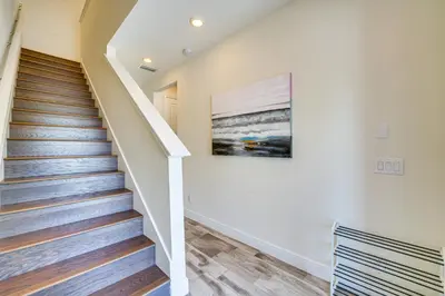 a staircase in a house with a painting on the wall at about 11 Mi to Disney Bright Kissimmee Townhome! in Orlando